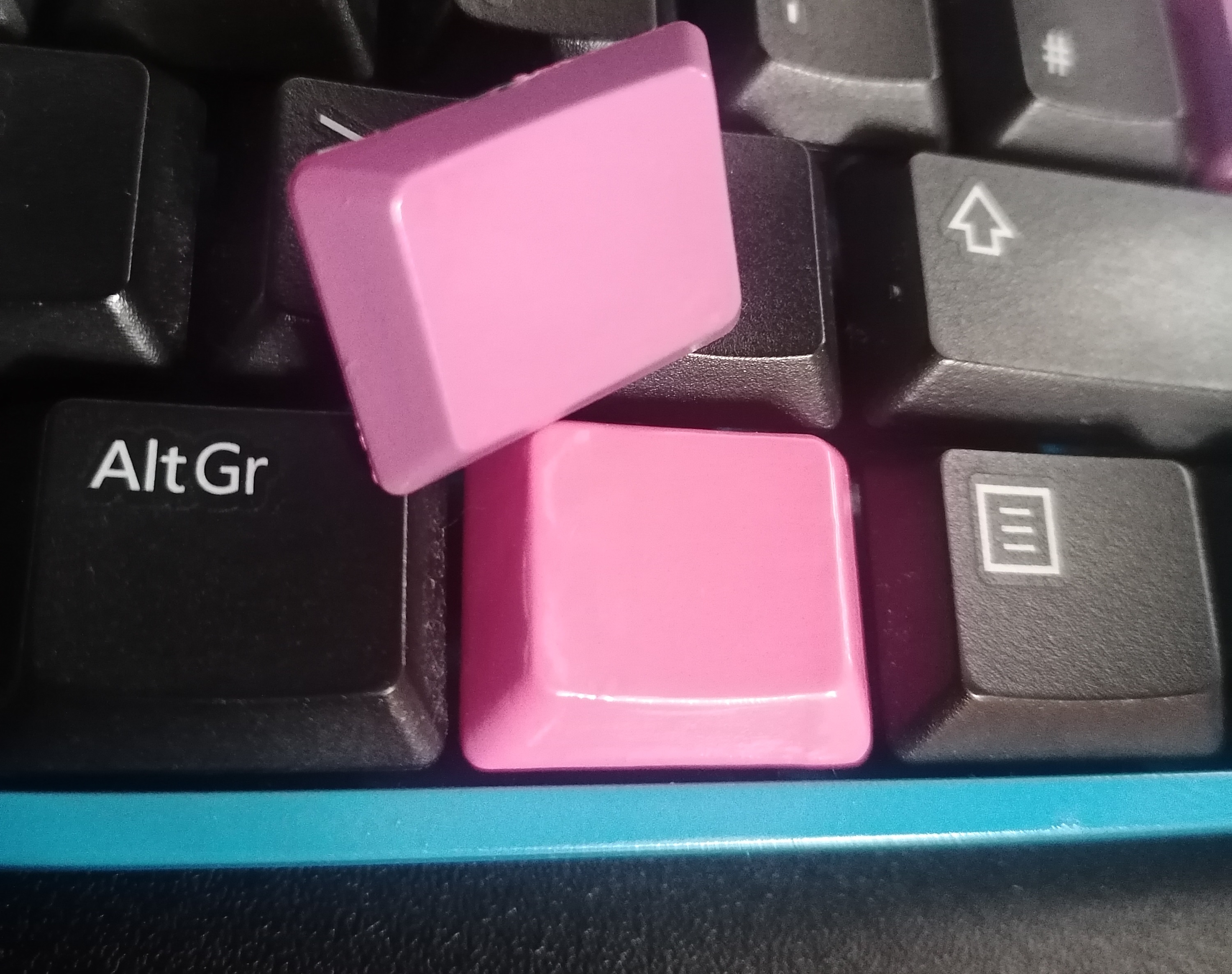 Two pink keys. One more vibrant with faint brushmarks is the varnish.
